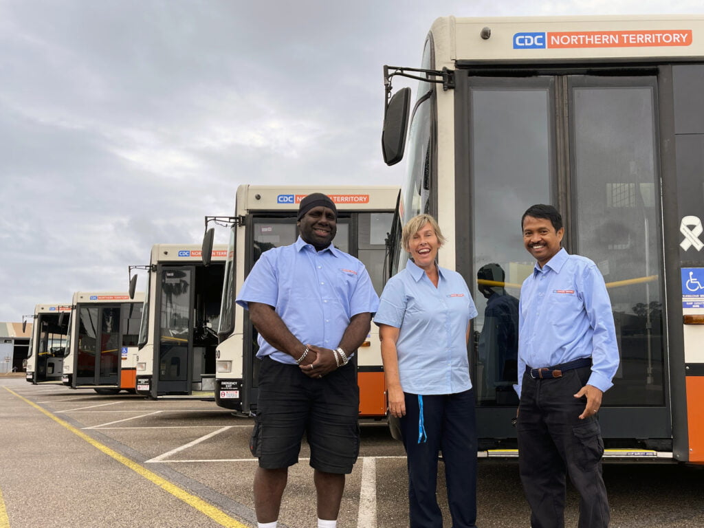 CDC NT Staff Smiling in Front of Buses